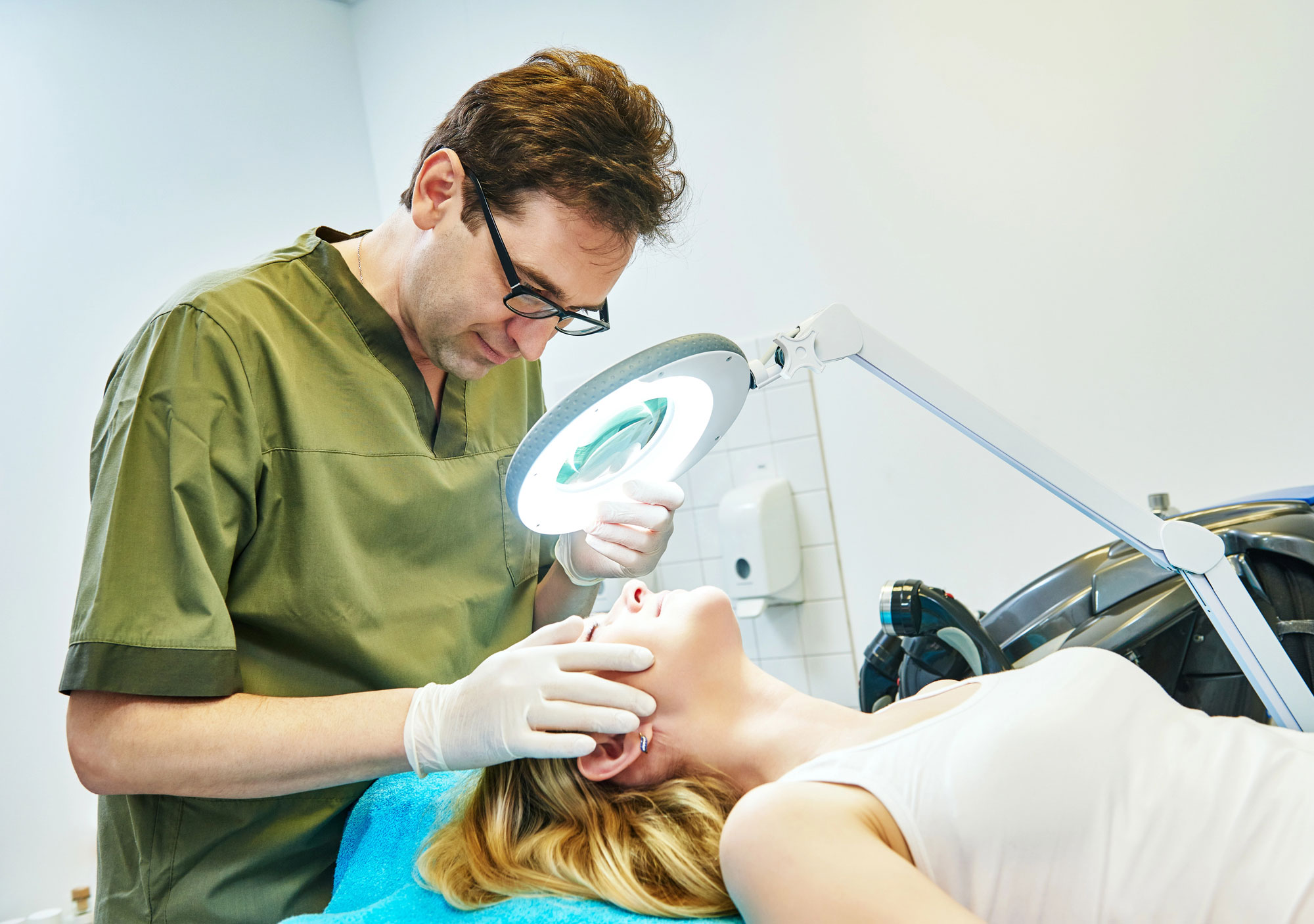 Doctor-cosmetologist-examining-woman-skin
